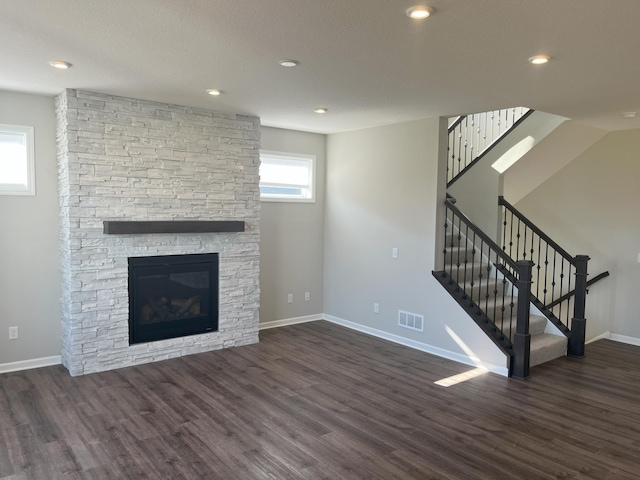 3790 Thrush St, Shakopee, MN 55379 - unfurnished living room with wood finished floors, a stone fireplace, stairway, and recessed lighting