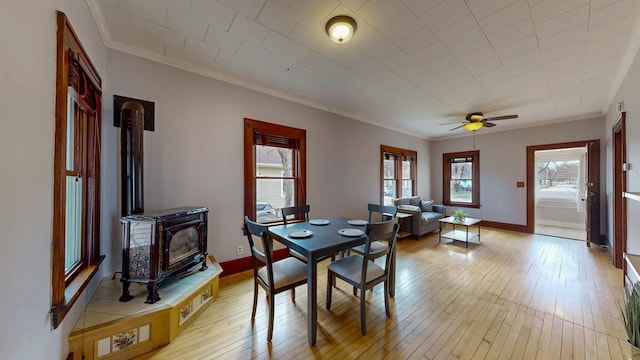 429 7th St NW, Rochester, MN 55901 - dining area with a wood stove, ceiling fan, light wood finished floors, and ornamental molding