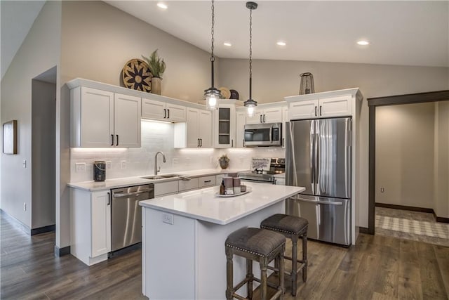 232 Chestnut St, Ellsworth, WI 54011 - kitchen featuring stainless steel appliances, white cabinets, tasteful backsplash, light countertops, and a center island