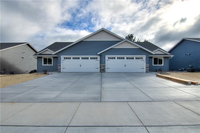 232 Chestnut St, Ellsworth, WI 54011 - craftsman-style house with a garage, driveway, and stone siding