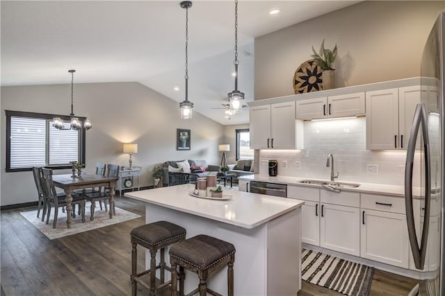 232 Chestnut St, Ellsworth, WI 54011 - kitchen with vaulted ceiling, white cabinets, light countertops, a kitchen island, and dark wood-style floors