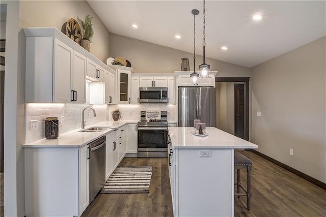 232 Chestnut St, Ellsworth, WI 54011 - kitchen featuring appliances with stainless steel finishes, a kitchen island, backsplash, white cabinetry, and light countertops