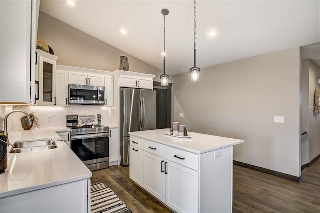 232 Chestnut St, Ellsworth, WI 54011 - kitchen with stainless steel appliances, decorative backsplash, dark wood finished floors, lofted ceiling, and white cabinetry
