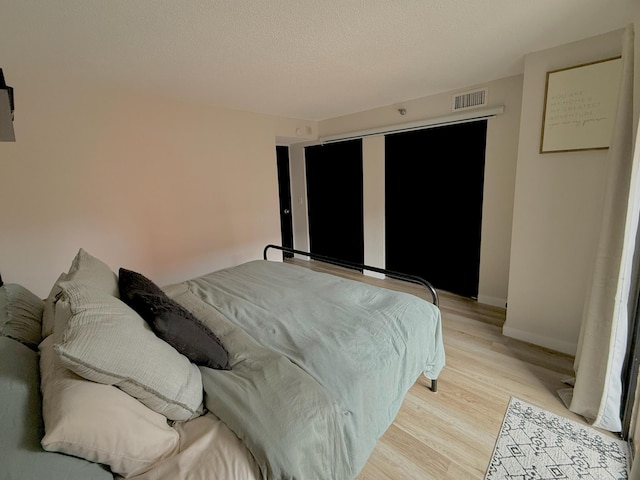 26 10th St W Unit 402, Saint Paul, MN 55102 - bedroom featuring light wood-style flooring and a textured ceiling