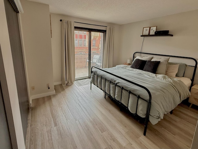 26 10th St W Unit 402, Saint Paul, MN 55102 - bedroom with light wood finished floors, a textured ceiling, and access to outside