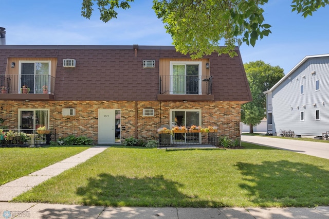 2575 Pacific Dr S Unit 301, Fargo, ND 58103 - view of front of property featuring a balcony, brick siding, a front yard, and roof with shingles