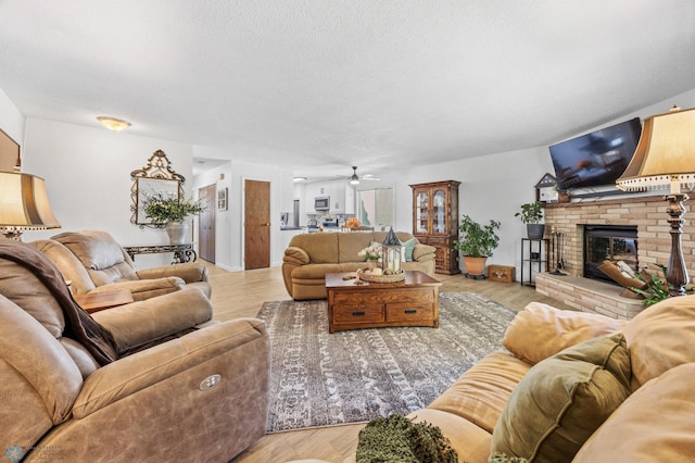 2575 Pacific Dr S Unit 301, Fargo, ND 58103 - living area featuring a ceiling fan, a brick fireplace, light wood finished floors, and a textured ceiling