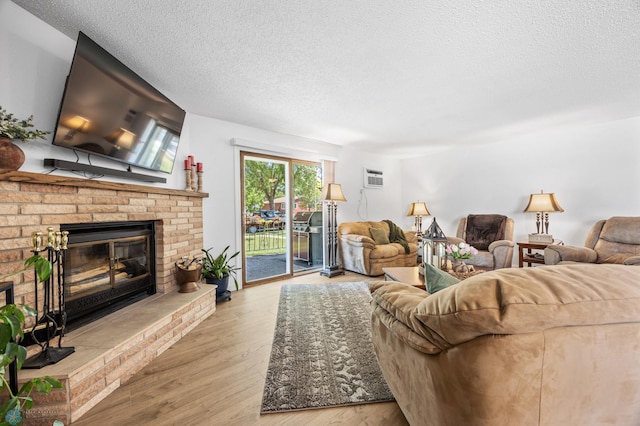 2575 Pacific Dr S Unit 301, Fargo, ND 58103 - living room featuring a brick fireplace, a textured ceiling, wood finished floors, and a wall unit AC