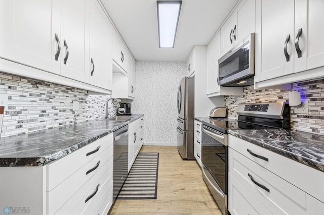 2575 Pacific Dr S Unit 301, Fargo, ND 58103 - kitchen with appliances with stainless steel finishes, light wood finished floors, backsplash, and white cabinets