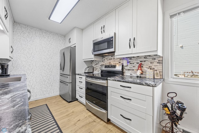 2575 Pacific Dr S Unit 301, Fargo, ND 58103 - kitchen with appliances with stainless steel finishes, light wood finished floors, white cabinets, tasteful backsplash, and wallpapered walls