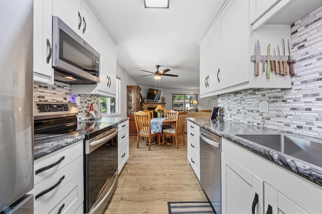 2575 Pacific Dr S Unit 301, Fargo, ND 58103 - kitchen with appliances with stainless steel finishes, backsplash, ceiling fan, light wood finished floors, and white cabinetry