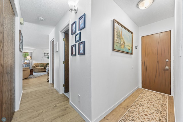 2575 Pacific Dr S Unit 301, Fargo, ND 58103 - hallway featuring a textured ceiling and light wood-style floors