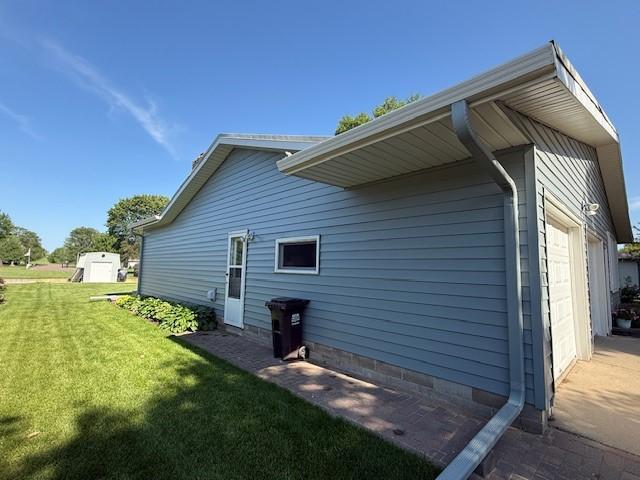2411 Douglas St, Windom, MN 56101 - view of side of property with a garage, a yard, and crawl space