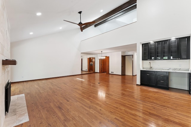 1775 Lexington Ave S Unit 26, Lilydale, MN 55118 - unfurnished living room with a fireplace, high vaulted ceiling, a ceiling fan, wet bar, and light wood-type flooring