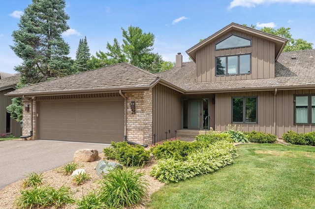 1775 Lexington Ave S Unit 26, Lilydale, MN 55118 - view of front of home featuring board and batten siding, a garage, asphalt driveway, a front yard, and brick siding