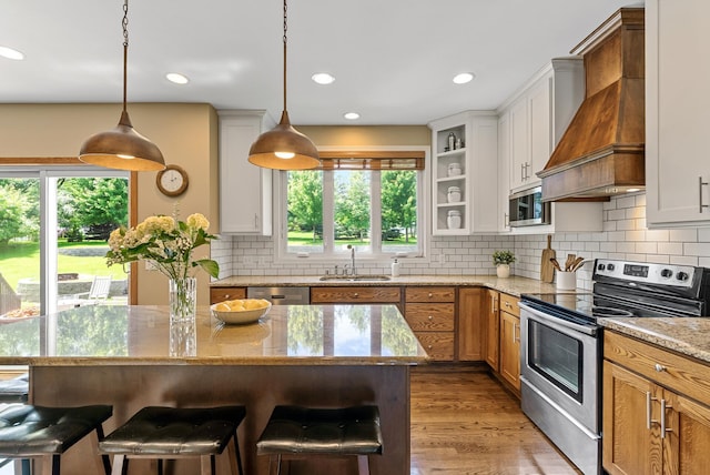 2227 Stone Creek Ln E, Chanhassen, MN 55317 - kitchen featuring appliances with stainless steel finishes, custom exhaust hood, a breakfast bar, backsplash, and recessed lighting