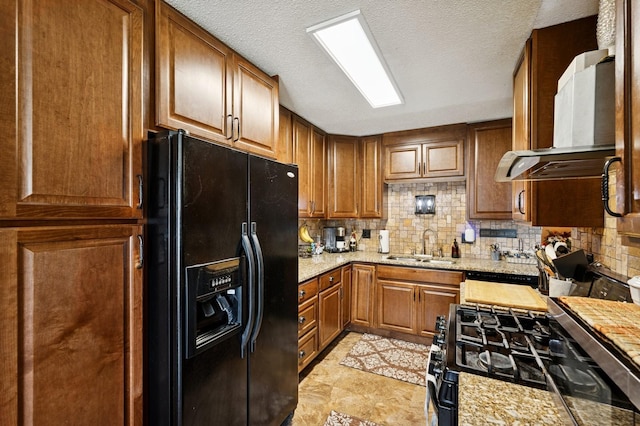 3950 Upper 75th St E, Inver Grove Heights, MN 55076 - kitchen featuring black refrigerator with ice dispenser, range with gas cooktop, wall chimney exhaust hood, decorative backsplash, and brown cabinets