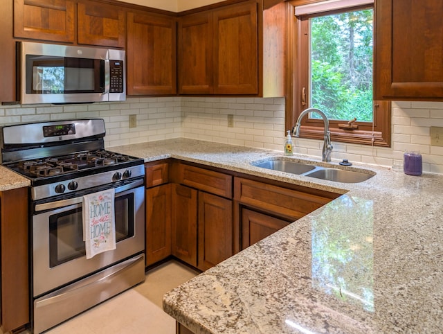1132 Westbury Cir, Eagan, MN 55123 - kitchen with stainless steel appliances, brown cabinetry, light stone counters, and backsplash
