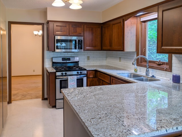 1132 Westbury Cir, Eagan, MN 55123 - kitchen with stainless steel appliances, a chandelier, light stone countertops, and a peninsula