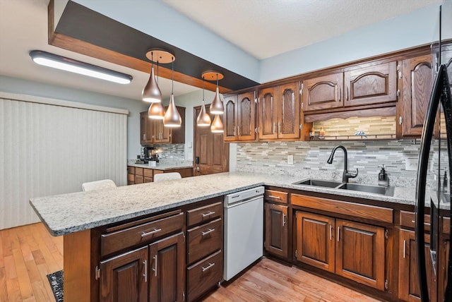 7795 Van Buren St NE, Spring Lake Park, MN 55432 - kitchen with white dishwasher, a peninsula, light wood finished floors, and tasteful backsplash