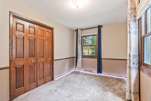 7795 Van Buren St NE, Spring Lake Park, MN 55432 - unfurnished bedroom featuring carpet flooring, a textured ceiling, and a closet