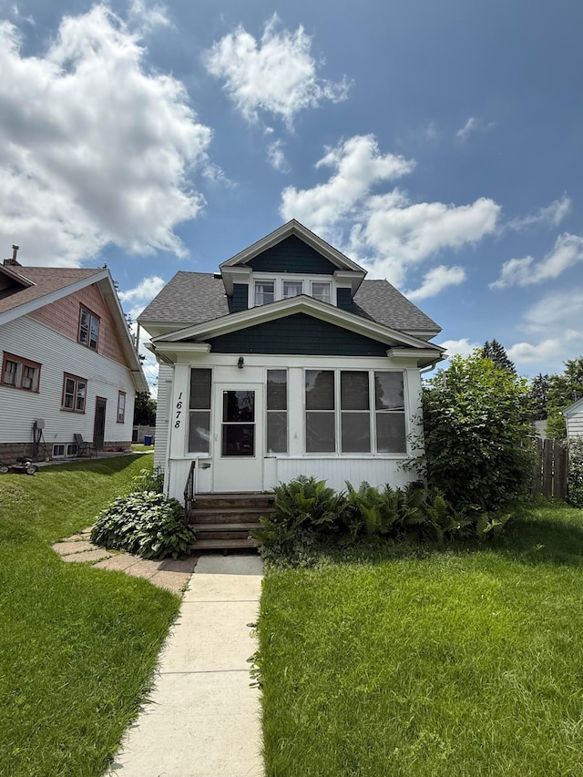 1678 Minnehaha Ave E, Saint Paul, MN 55106 - bungalow-style house with entry steps, a front lawn, and roof with shingles