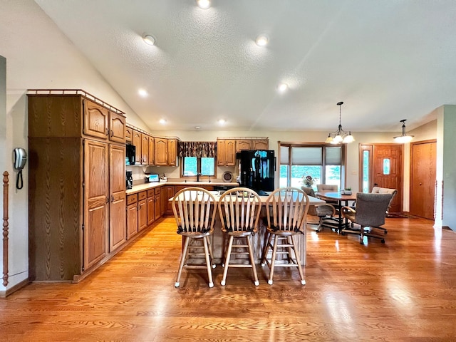 4095 125th St SE, Granite Falls, MN 56241 - kitchen featuring black refrigerator, light wood-style floors, a kitchen island, a chandelier, and light countertops