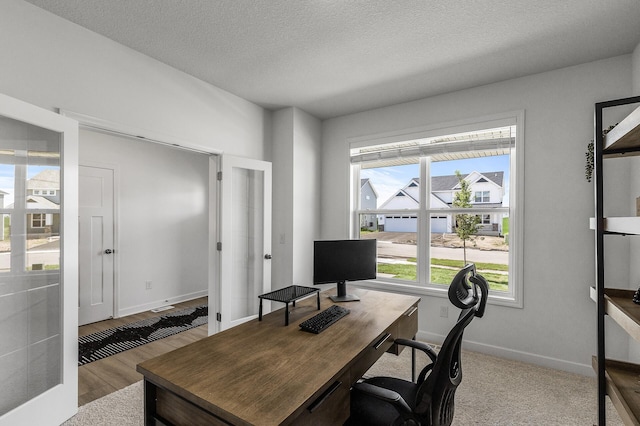 1959 Tamarack Rd, Carver, MN 55315 - home office with healthy amount of natural light, french doors, a textured ceiling, and wood finished floors