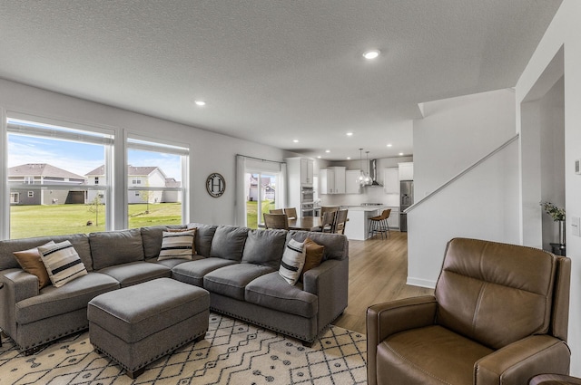 1959 Tamarack Rd, Carver, MN 55315 - living area featuring light wood-style flooring, a textured ceiling, recessed lighting, and stairway