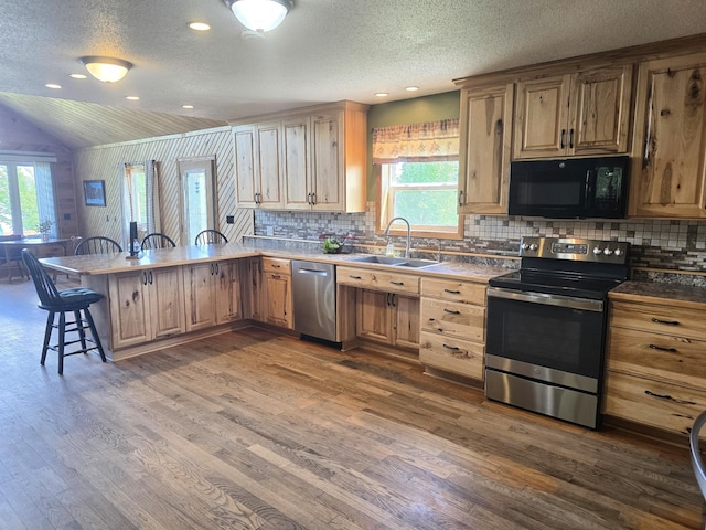 45356 140th St, Swan Lake Twp, MN 56235 - kitchen with appliances with stainless steel finishes, a breakfast bar, a peninsula, dark wood-type flooring, and a textured ceiling