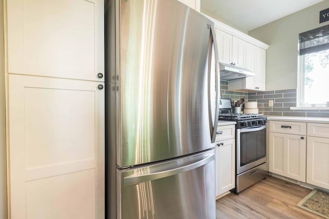18377 County Highway 25, Fergus Falls, MN 56537 - kitchen with stainless steel appliances, under cabinet range hood, white cabinets, light countertops, and decorative backsplash