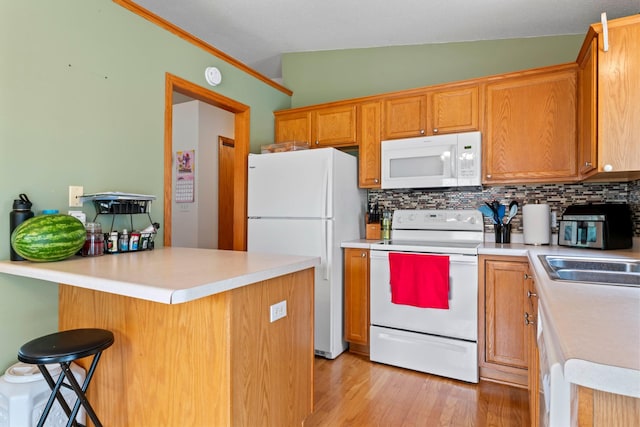 3902 Strathmore Ln SE, Rochester, MN 55904 - kitchen with white appliances, tasteful backsplash, light wood-type flooring, light countertops, and a kitchen bar