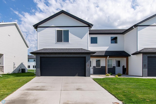 1449 68th Ave S, Fargo, ND 58104 - view of front facade featuring brick siding, a front lawn, a garage, and driveway