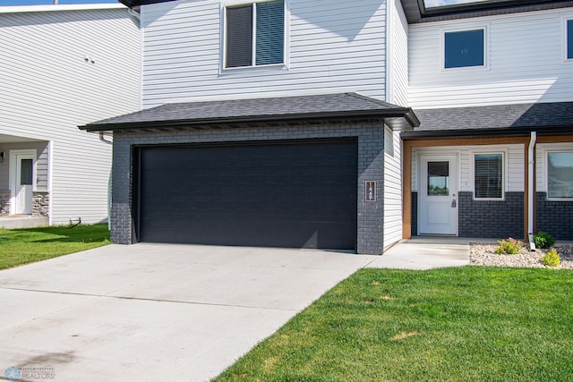 1449 68th Ave S, Fargo, ND 58104 - view of front of house featuring brick siding, an attached garage, concrete driveway, and a front yard