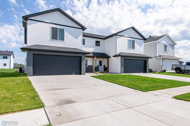 1449 68th Ave S, Fargo, ND 58104 - view of front of home featuring a garage, concrete driveway, a front yard, and brick siding