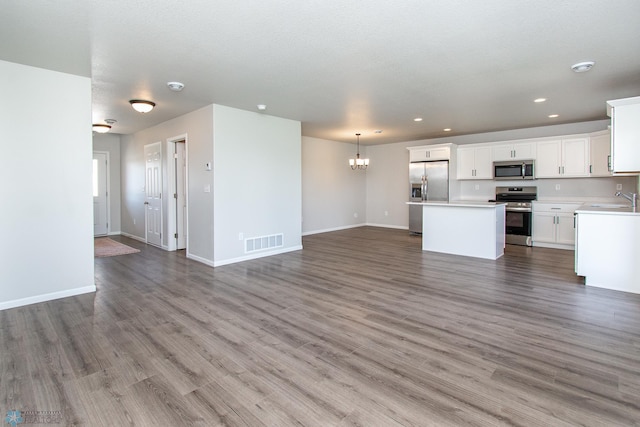 1449 68th Ave S, Fargo, ND 58104 - unfurnished living room featuring a chandelier, wood finished floors, and recessed lighting