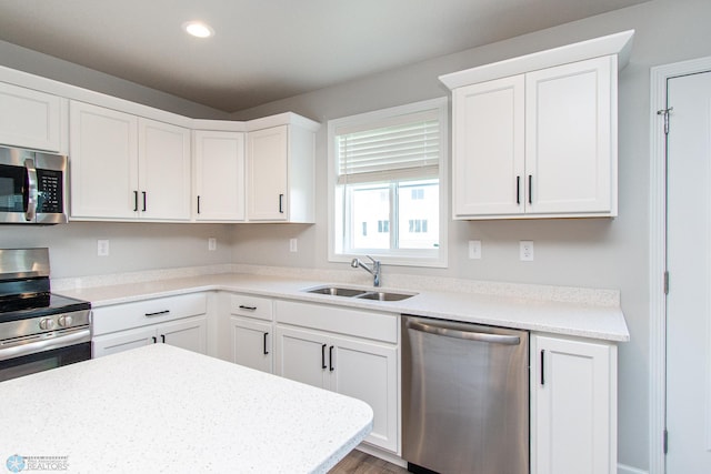 1449 68th Ave S, Fargo, ND 58104 - kitchen with appliances with stainless steel finishes, white cabinets, recessed lighting, and wood finished floors