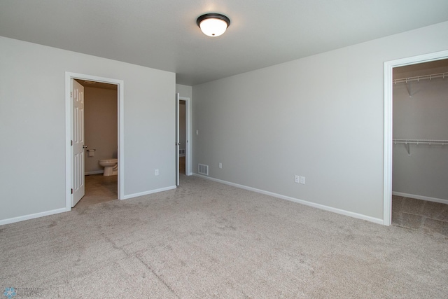 1449 68th Ave S, Fargo, ND 58104 - unfurnished bedroom featuring a spacious closet, carpet flooring, a closet, and ensuite bathroom