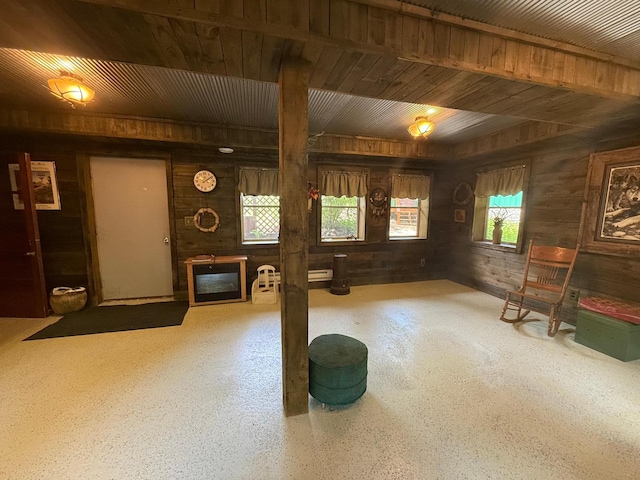 40257 Elbow Lake Store Rd, Round Lake N Twp, MN 56589 - unfurnished living room featuring wooden walls, speckled floor, and a glass covered fireplace