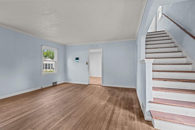 1289 Galtier St, Saint Paul, MN 55117 - unfurnished living room with ornamental molding, stairway, and hardwood / wood-style floors