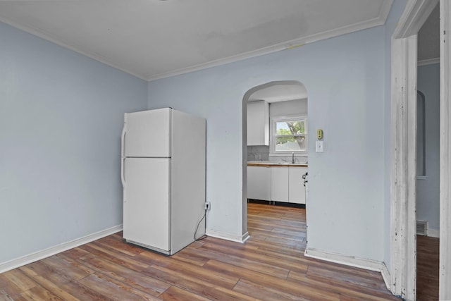 1289 Galtier St, Saint Paul, MN 55117 - empty room featuring arched walkways, ornamental molding, and wood finished floors