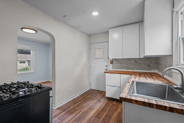 1289 Galtier St, Saint Paul, MN 55117 - kitchen with black gas range oven, butcher block counters, white cabinetry, dark wood-style floors, and backsplash