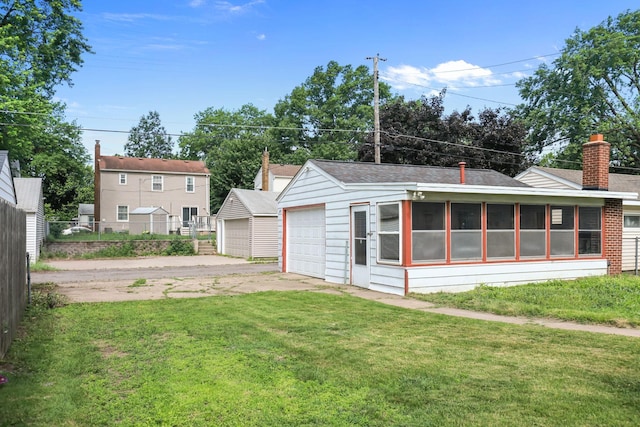 1289 Galtier St, Saint Paul, MN 55117 - back of property with a garage, a chimney, a shingled roof, and an outbuilding