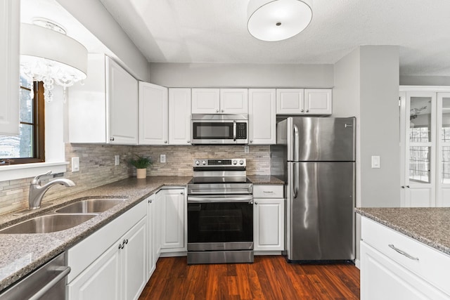 1237 Hillwind Rd NE, Fridley, MN 55432 - kitchen featuring appliances with stainless steel finishes, tasteful backsplash, and white cabinets