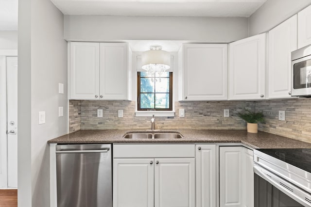 1237 Hillwind Rd NE, Fridley, MN 55432 - kitchen with appliances with stainless steel finishes, backsplash, white cabinets, and dark countertops