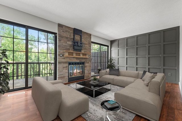 1237 Hillwind Rd NE, Fridley, MN 55432 - living room featuring a decorative wall, healthy amount of natural light, a stone fireplace, and wood finished floors