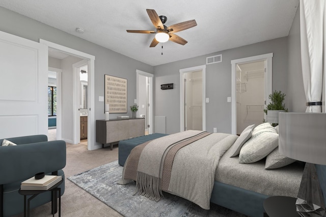 1237 Hillwind Rd NE, Fridley, MN 55432 - bedroom featuring light carpet, a walk in closet, ensuite bathroom, and ceiling fan
