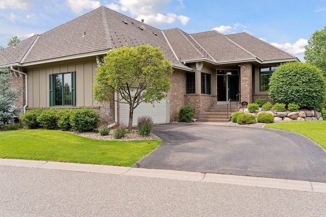 343 Waycliffe Dr N, Wayzata, MN 55391 - view of front facade with brick siding, a garage, a front lawn, driveway, and board and batten siding