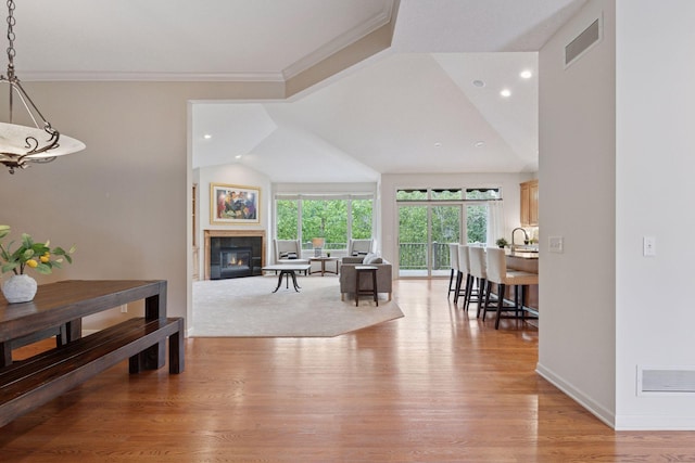 343 Waycliffe Dr N, Wayzata, MN 55391 - living room featuring light wood-style flooring, a glass covered fireplace, ornamental molding, lofted ceiling, and recessed lighting