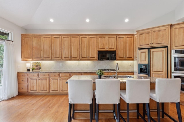 343 Waycliffe Dr N, Wayzata, MN 55391 - kitchen with black microwave, paneled refrigerator, a center island with sink, double oven, and backsplash